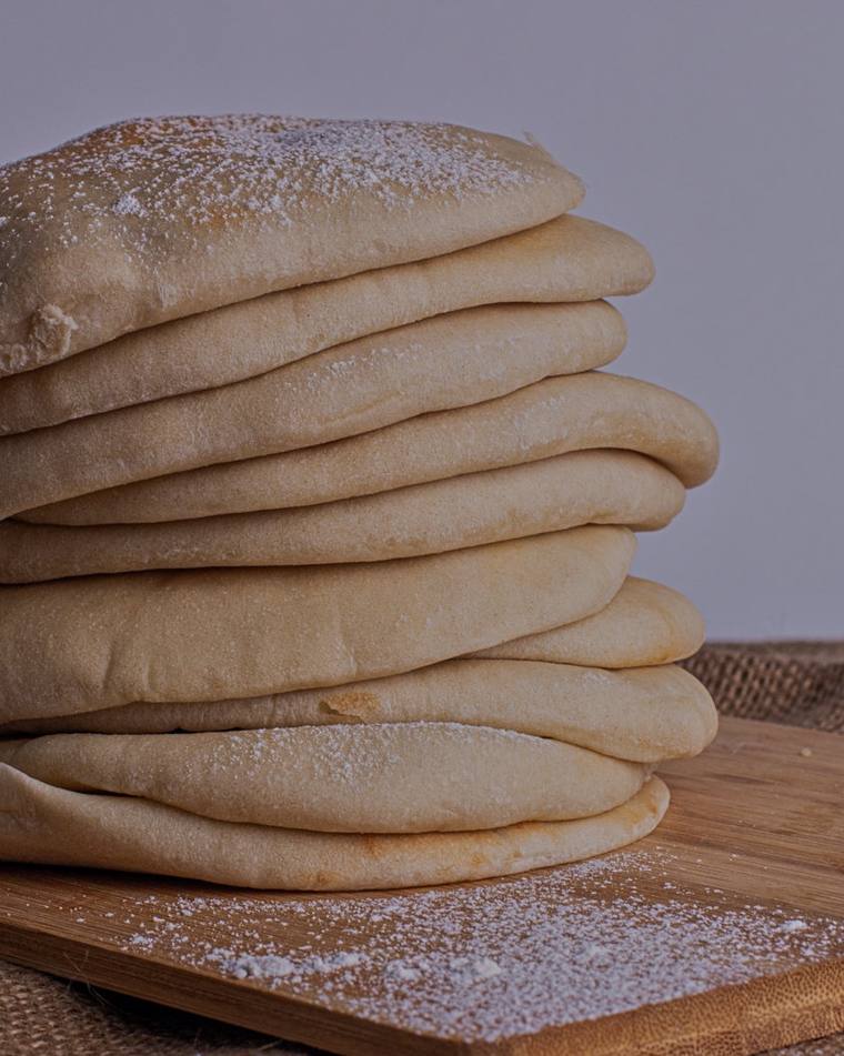 Pila de pitas recién horneadas sobre una tabla de madera